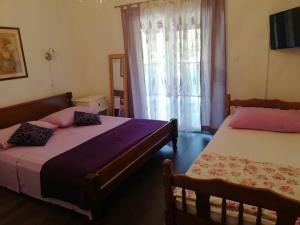 a bedroom with two beds and a window at Apartments Rogac in Rogač