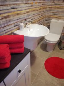 a bathroom with a white sink and red towels at Apartments Rogac in Rogač +24 photos