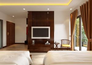 a bedroom with two beds and a flat screen tv at Tam Coc Catalina Hotel By ANMS GROUP in Ninh Binh