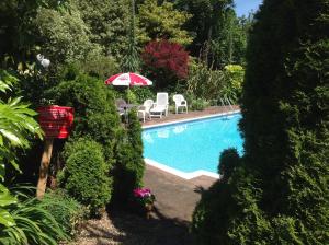 セント・マーティン・ガーンジーにあるLa Micheleの赤と白のパラソルと椅子が備わるスイミングプール +23枚の写真