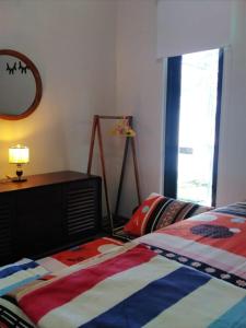 a bedroom with a bed and a dresser and a window at Family Villa Syariah C-37 Batu in Batu