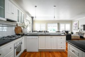 uma cozinha com armários brancos e um forno com placa de fogão em Bright 29 em Bright