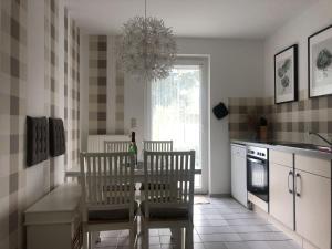 a kitchen with a table and two chairs and a chandelier at Bright Apartment in Boltenhagen near the Sea in Boltenhagen