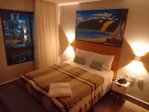 Habitación de hotel con 1 cama con 2 lámparas en Ilusion Flats Aconchego de Ponta Negra, en Natal