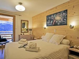 ein Schlafzimmer mit einem großen Bett mit Handtüchern darauf in der Unterkunft Appartement neuf aux Ménuires avec terrasse et parking - FR-1-613B-22 in Levassaix
