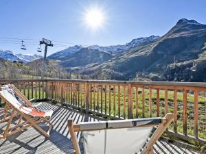 eine Terrasse mit Stühlen und Blick auf die Berge in der Unterkunft Appartement neuf aux Ménuires avec terrasse et parking - FR-1-613B-22 in Levassaix
