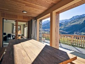 einen Holztisch auf einer Veranda mit Bergblick in der Unterkunft Appartement neuf aux Ménuires avec terrasse et parking - FR-1-613B-22 in Levassaix + 11 Fotos
