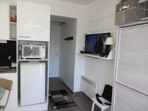 uma pequena cozinha com um micro-ondas e uma televisão em Studio Chamrousse, 1 pièce, 3 personnes - FR-1-340-264 em Chamrousse