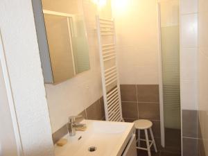 baño con lavabo, espejo y taburete en Studio Chamrousse, 1 pièce, 3 personnes - FR-1-340-264, en Chamrousse