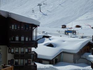 pokryty śniegiem budynek z wyciągiem narciarskim w tle w obiekcie Studio lumineux 3 pers · Balcon · Animaux acceptés · Proche pistes et commerces - FR-1-502-471 w mieście Tignes