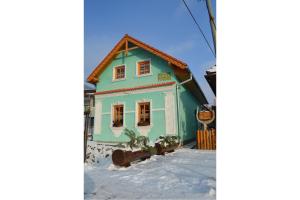 una casa azul y verde en la nieve en Chalupa Sonja, en Lúčky