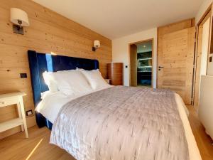 - une chambre avec un grand lit et un mur en bois dans l'établissement Appartement Montvalezan-La Rosière, 4 pièces, 8 personnes - FR-1-275-196, à La Rosière