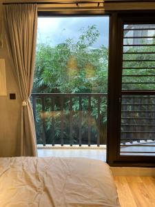 a bedroom with a window with a view of a balcony at hsueh_house in Yilan City