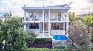 a large white house with a swimming pool at Paralian in Kingscliff