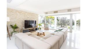 a living room with a white couch and a tv at Paralian in Kingscliff