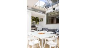 a dining room with a white table and chairs at Paralian in Kingscliff