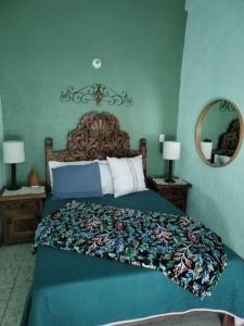 a blue bedroom with a bed and a mirror at Casa Chelito con Terraza in Guanajuato