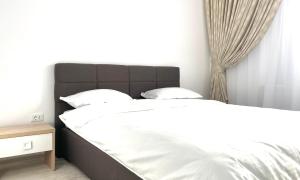 a bedroom with two beds with white sheets at Luxury apartments in Suceava