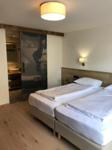 Zimmer mit 2 Betten und einem Bad mit einem Spiegel in der Unterkunft Wittner's in Söll