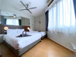 1 dormitorio con 2 camas y ventilador de techo en D'concept Hotel Kulim, en Kulim