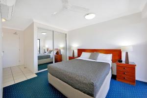 a hotel room with a bed and a mirror at 404b Coral Sands in Bargara