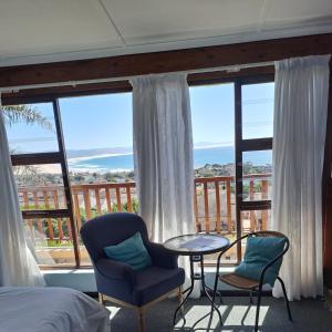 Jeffreys Bay的住宿－A1 Kynaston self catering or bed and breakfast solarpower，卧室配有一张床和一张桌子及椅子