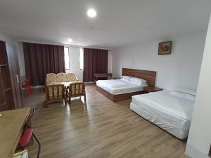 a hotel room with two beds and a table at OYO 90809 Oriental Hotel in Sarikei