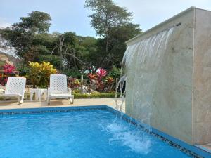 a swimming pool with a water fountain at Canoa South Beach in Canoa