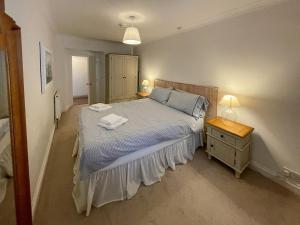 a bedroom with a bed and a nightstand with two towels on it at Petra 1-uk39857 in Marazion