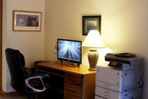 een kamer met een bureau, een computer en een lamp bij The Driftwood Lodge in Juneau