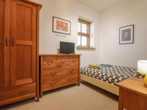 a bedroom with a bed and a dresser with a television at Grey Roofs in Stanton