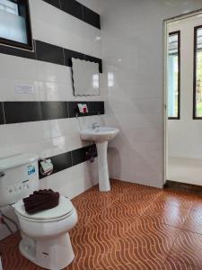 a bathroom with a toilet and a sink at Palm Tian Homes A17 in Ban Chong Phli