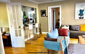 a living room with a couch and a table at Romantic cottage with amazing garden in Glendale