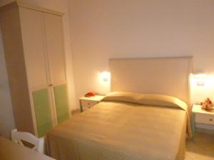 a small bedroom with a bed and two tables at Hotel Basilea in Bellaria-Igea Marina