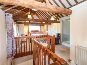 a room with a bedroom and a bed with wooden ceilings at The Dairy in Ashill