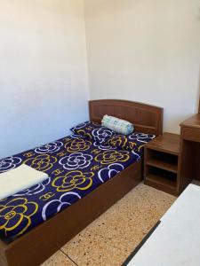 a bedroom with a bed with a blue and yellow bedspread at RC Apartment in Krabi