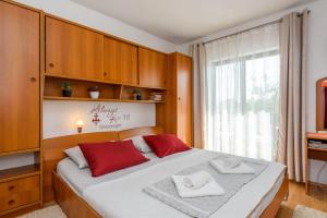 a bedroom with a large bed with red pillows on it at Apartments Goge - 90m from beach in Gradac