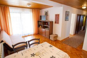 sala de estar con mesa, sillas y ventana en Apartments and rooms Ivan - great location, en Novalja