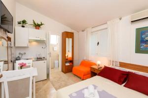a small apartment with an orange couch and a kitchen at Apartments Goge - 90m from beach in Gradac