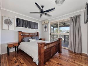 a bedroom with a bed and a ceiling fan at 242 Woongarra Scenic Drive in Bargara