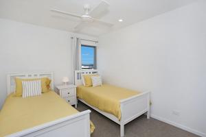 um quarto com 2 camas e uma janela em Ocean Terrace em Kingscliff