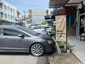 a car parked next to a sign on a street at Sleep Sheep Phuket Hostel SHA in Phuket Town