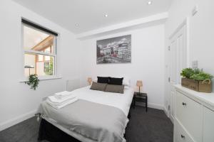 a white bedroom with a bed and a window at Your Own House, 2 Bedr, 3 Beds, 2,5 Bath, Covent Gdn in London