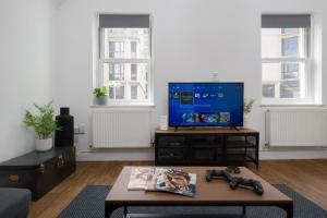 a living room with a tv and a table at Your Own House, 2 Bedr, 3 Beds, 2,5 Bath, Covent Gdn in London