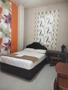 a bedroom with a bed and a window at Mojokerto Classic Homestay in Mojokerto
