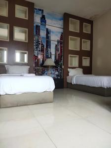 a bedroom with two beds and a painting of a city at Mojokerto Classic Homestay in Mojokerto
