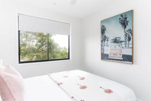 a white room with two windows and a white couch at Ohana On Hungerford in Kingscliff