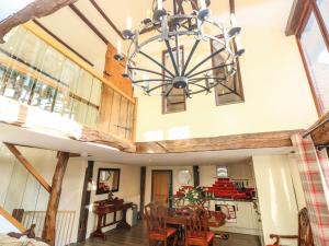 a dining room and kitchen with a chandelier at The Barn in Ashill