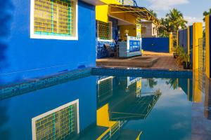 a house and its reflection in a swimming pool at Shalom Backpackers Anjuna Goa in Anjuna
