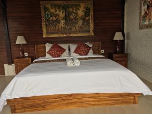 a bedroom with a large white bed with two bows at Amed Sunset Beach in Amed